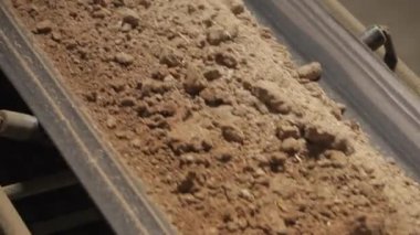 Çalışan ve kum taşıyan makineler. Endüstrideki taşıma bandı, seramik fabrika ekipmanları, taşıyıcıdaki kilin taşınması.