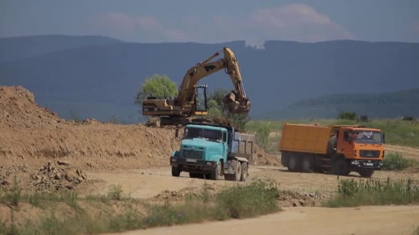 Una excavadora excava carbón y lo vierte en un camión volquete grande — Vídeos de Stock