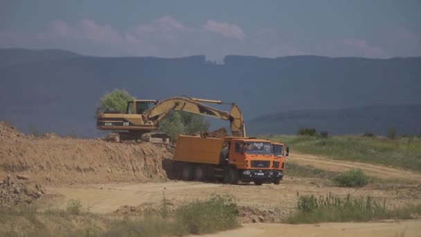 Una excavadora excava carbón y lo vierte en un camión volquete grande — Vídeos de Stock