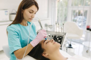 Profesyonel kadın kozmetikçi güzel bir kız için ortanca işlem yapıyor. Yumuşak ten. Kozmetik Kliniği