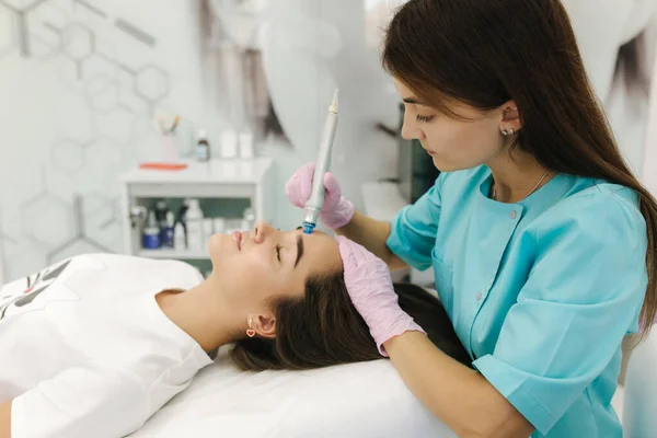 Professional female cosmetologist doing hydrafacial procedure for beautiful girl. Soft skin. Cosmetology clinic — Stock Photo, Image
