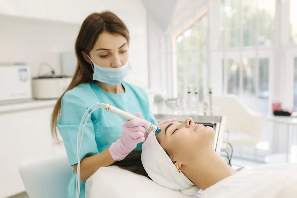Professional female cosmetologist doing hydrafacial procedure in Cosmetology clinic. Doctor use hydra vacuum cleaner. Rejuvenation And Hydratation. Cosmetology — Stock Photo, Image