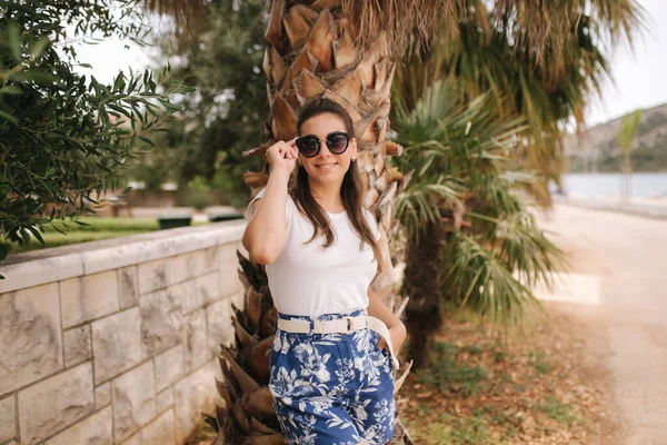 Mujer joven en pantalones cortos azules caminando al aire libre sola en la calle. Tropical — Foto de Stock