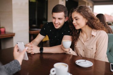 Bir grup ağaç arkadaş terasta. İnsanlar kafede buluşuyor. Kafede birlikte oturan arkadaşlar. Akıllı telefonunda bir çift için bir kadın şovu