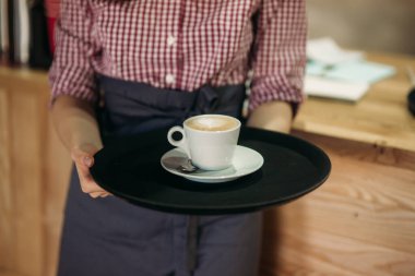 Garson kafede kahve ikram ediyor. kapuçino