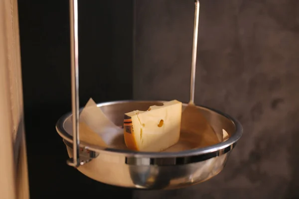 Een stuk kaas weegt in een kaaswinkel. Stuk maasdammer kaas — Stockfoto