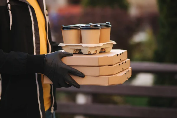 Närbild av kurir ge order till kund. Man från leveransservice ta med pizza och kaffe. Händerna i skyddsmask — Stockfoto