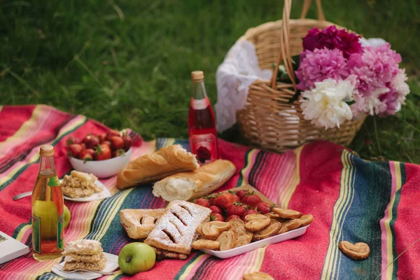 Фото мини-пикника на открытом воздухе. Безалкогольный пикник. Свежая клубника, лимонад и безглютеновый хлеб. Красное одеяло — стоковое фото
