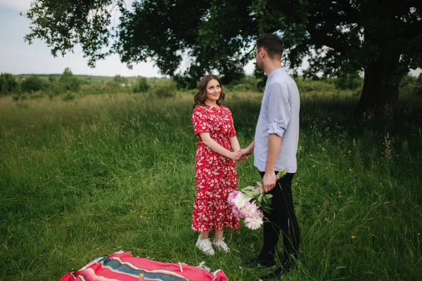 Glückliche Frau mit ihrem geliebten Mann hat ein Mini-Picknick am großen Baum. Schönes Paar im Freien — Stockfoto