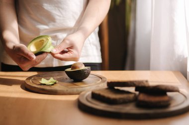 Kadın haplarından oluşan orta seçim evdeki tahta tahtada bir avokado. Vejetaryen gıda konsepti