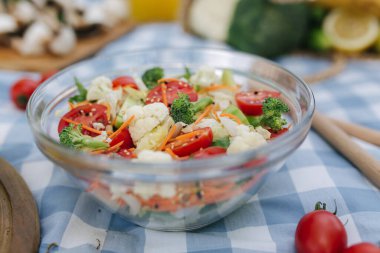 Açık havada taze vejetaryen salatası ve mavi peçete. Vejetaryen yemek konsepti.