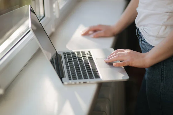 Закрытие покупок молодой женщины в Интернете с помощью ноутбука и кредитной карты. Ноутбук на подоконнике — стоковое фото