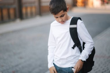 Genç çocuk cep telefonunun kablosuz kulaklığından aldı.