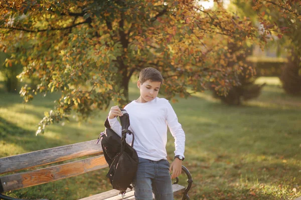 El colegial va a la escuela por la mañana. Adolescente feliz en camisa blanca con mochila negra ir a estudiar — Foto de Stock