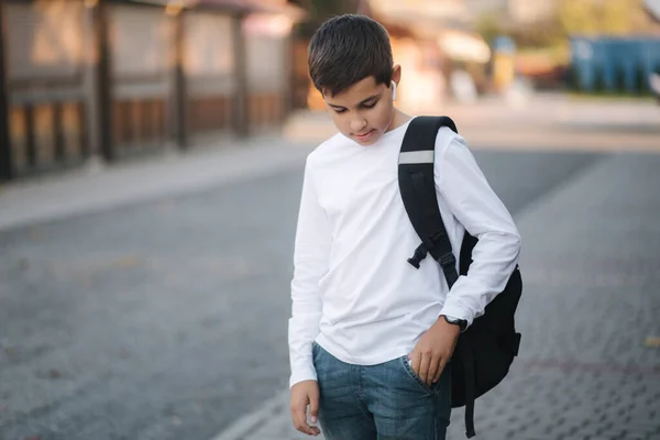 Adolescente menino tirar a partir do bolso fones de ouvido sem fio — Fotografia de Stock