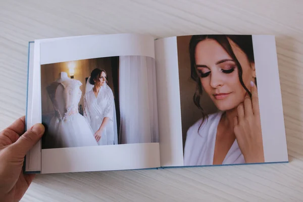 Photobook ouvert avec mariée sur table en bois blanc — Photo