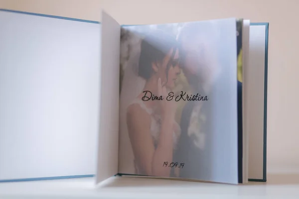 Photobook ouvert avec papier calque avec marié et mariée sur table en bois blanc — Photo