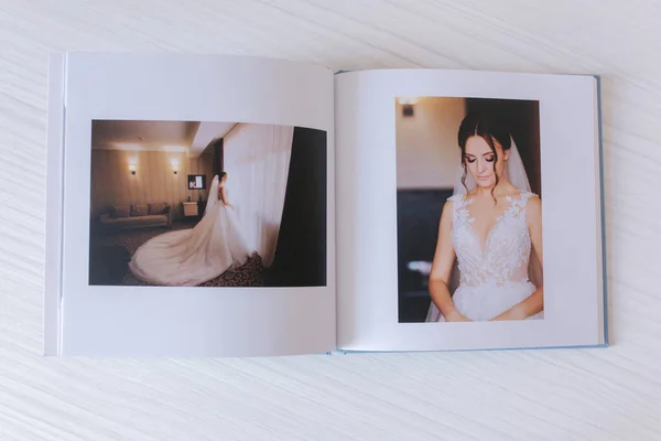 Photobook ouvert avec mariée sur table en bois blanc — Photo