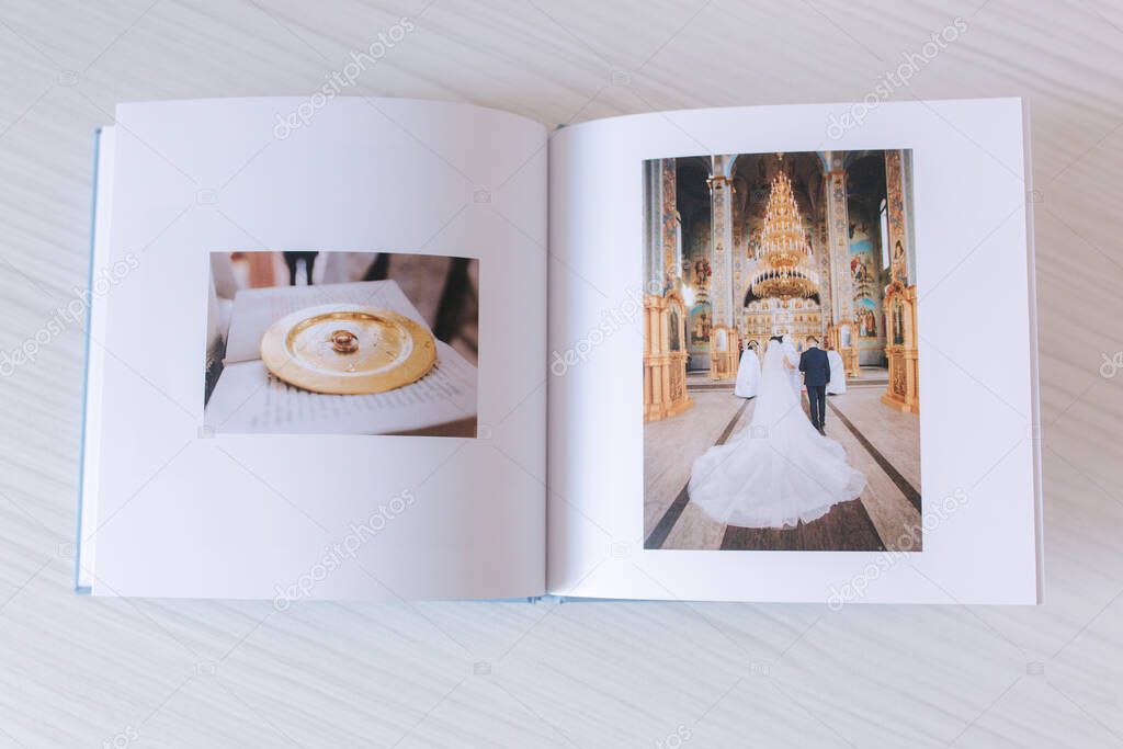 Open photobook with wrdding photo of beautiful couple on white wooden table