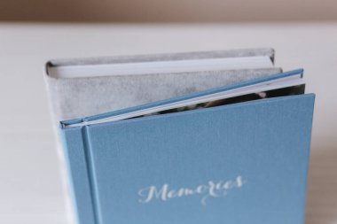 Beyaz ahşap masada 20 'ye 20' lik iki sarhoş kitap. İki düğün kitabının karşılaştırması. Mavi ve gri fotobooks