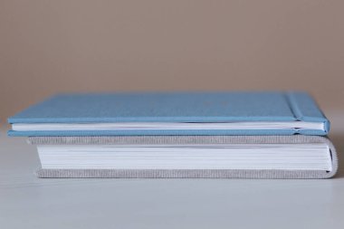Beyaz ahşap masa üzerinde iki kapalı fotoobook görünümü