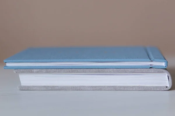 Vue sur le bout de deux photobooks fermés sur une table en bois blanc — Photo