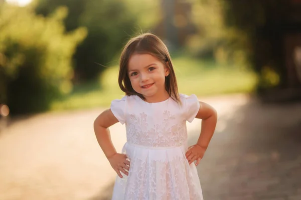 Egy boldog mosolygós kislány portréja fehér ruhában. — Stock Fotó