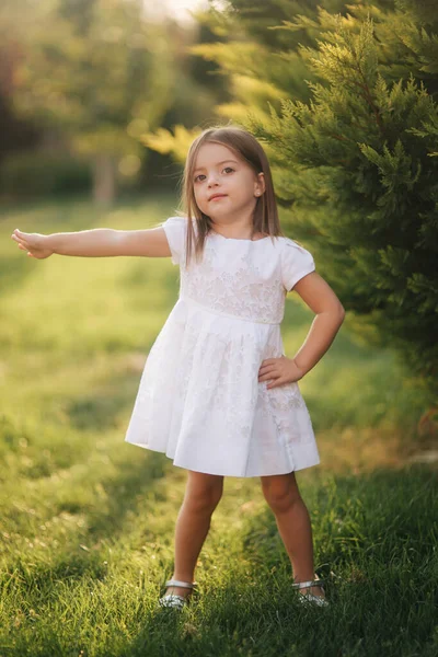 Hermosa niña en vestido blanco caminando al aire libre en la espalda yaer de casa. Chico feliz — Foto de Stock