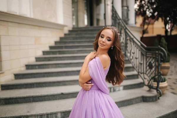 Retrato de mujer elegante en vestido de noche púrpura caminando al aire libre por restaurante — Foto de Stock