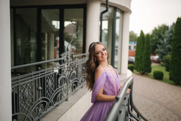 Portret van elegante vrouw in paarse avondjurk wandelen buiten door restaurant — Stockfoto