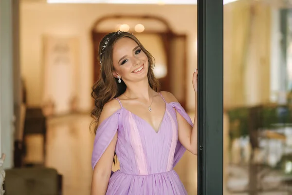 Young woman in beautiful purple dress posing to photographer by the restaurant — Stock Photo, Image