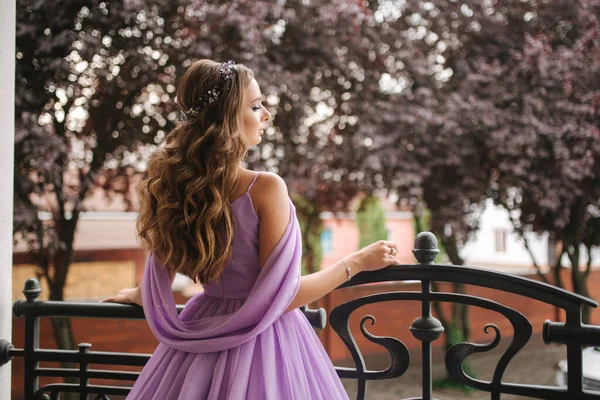 Vue arrière de la femme en robe de soirée se tenir sur la terrasse et sourire. Belle coiffure — Photo