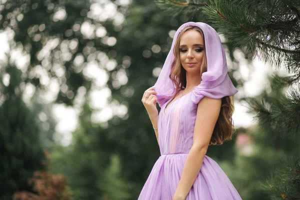 Jonge vrouw in elegante avondjurk met kap, buiten — Stockfoto