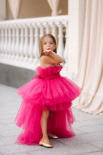 Beautiful little girl in pink fluffy dress give an air kiss — Stock Photo, Image