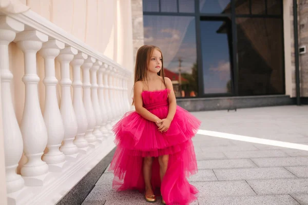 Adorable modèle de petite fille en robe rose moelleuse promener à l'extérieur par le restaurant. Joyeux petit enfant — Photo