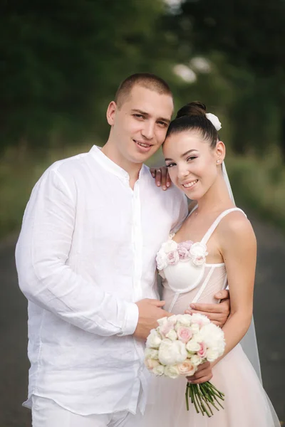 ハンサムな新郎と若いと美しい花嫁はお互いのキスと笑顔抱擁。幸せな結婚式のカップルの肖像 — ストック写真