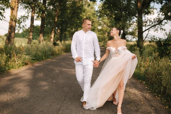 Waren und Braut spazieren am Hochzeitstag durch den Park. Sommerhochzeit — Stockfoto
