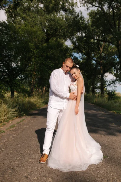 Waren und Braut spazieren am Hochzeitstag durch den Park. Sommerhochzeit — Stockfoto