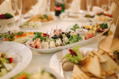 Düğünde yemek ve içeceklerle dolu bir masa. Restoranda servis edilir ve dekore edilir.