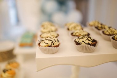 Lokantadaki çikolata masasında. Beyaz masada yaban mersinli tatlı tatlılar