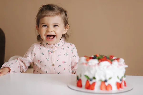 Aranyos kislány egy és egy Hulf éves stand finom szülinapi torta. Tizennyolc hónapos lány nagyon boldog és nevet — Stock Fotó