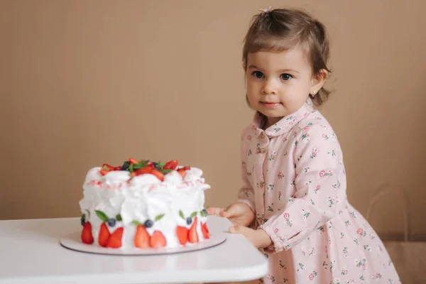 귀여운 1 살짜리 여자 애가 맛있는 생일 케익 옆에 서 있는 거. 18 개월된 여자 애가 즐겁게 웃고 있어. 채식 음식. 유당이 없고 글루텐이 없다. — 스톡 사진