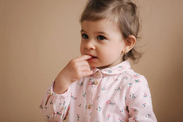 Niña primera vez probar bithday pastel. Linda niña en hermoso vestido degustación de pastel con fresas — Foto de Stock