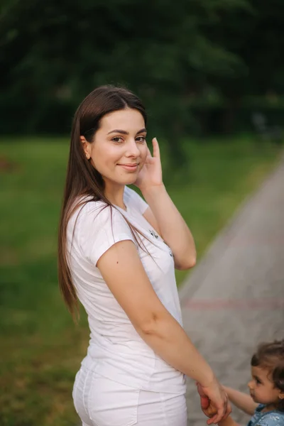 Vacker mamma går med sin bedårande lilla flicka i parken — Stockfoto