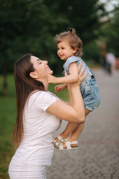 Boční pohled na maminku držet holčičku na rukou a bavit se — Stock fotografie