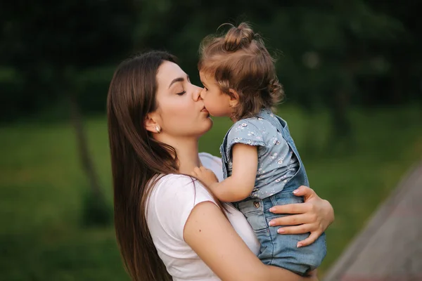 Portretul unei mame frumoase cu o fetiță adorabilă. O familie fericită în aer liber. Fiica da sarut la mama — Fotografie, imagine de stoc