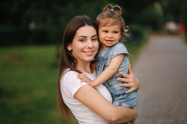 Portretul unei mame frumoase cu o fetiță adorabilă. O familie fericită în aer liber. Fiica imbratisare mama — Fotografie, imagine de stoc