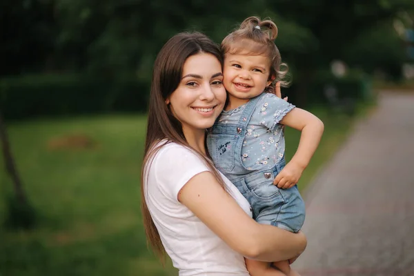 Portretul unei mame frumoase cu o fetiță adorabilă. O familie fericită în aer liber. Fiica imbratisare mama — Fotografie, imagine de stoc