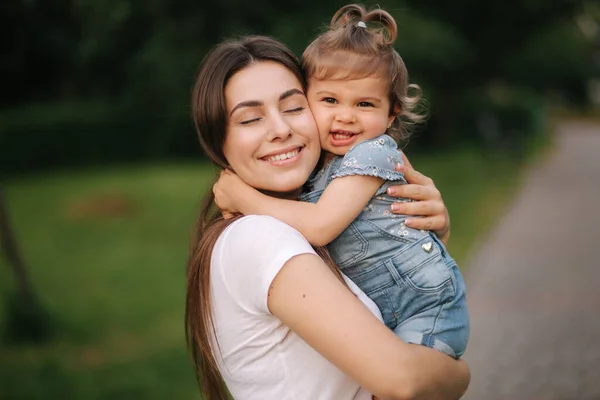 Ritratto di bella mamma con adorabile bambina. Famiglia felice all'aperto. Figlia abbraccio mamma — Foto Stock