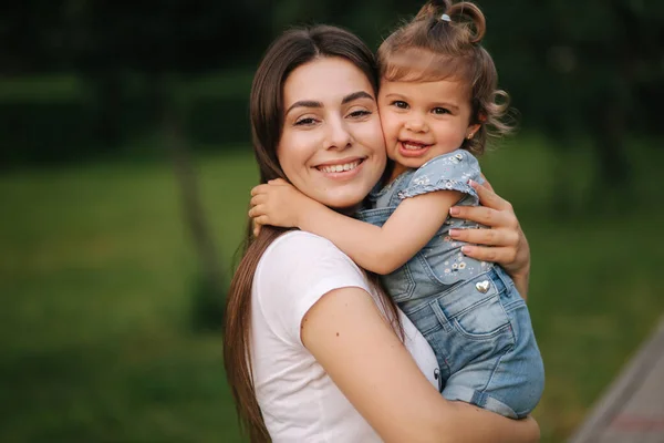 Ritratto di bella mamma con adorabile bambina. Famiglia felice all'aperto. Figlia abbraccio mamma — Foto Stock